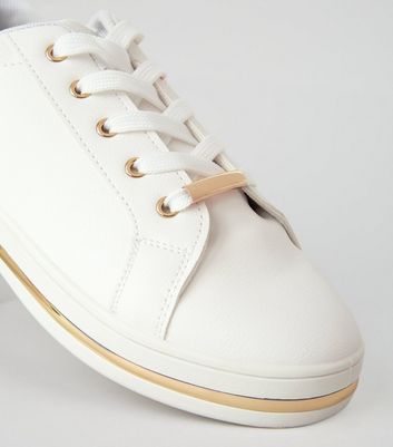 white sneakers with gold trim