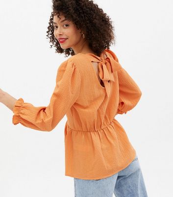 Click to view product details and reviews for Tall Orange Textured Tie Back Peplum Blouse New Look.