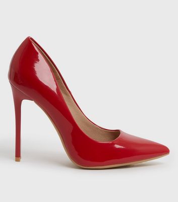 Premium Photo | A pair of red high heeled shoes with a red design on the  bottom.