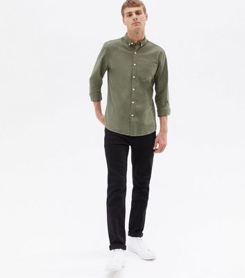a man wearing khaki pants and a green shirt and white shoes Stock Photo by  Icons8