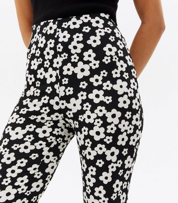 Click to view product details and reviews for Petite Black Floral Crinkle Jersey Flared Trousers New Look.