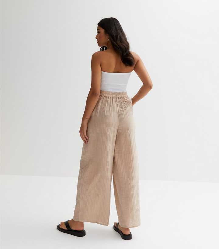 https://media2.newlookassets.com/i/newlook/864391816M3/womens/clothing/trousers/petite-stone-cotton-pleated-wide-leg-trousers.jpg?strip=true&qlt=50&w=720