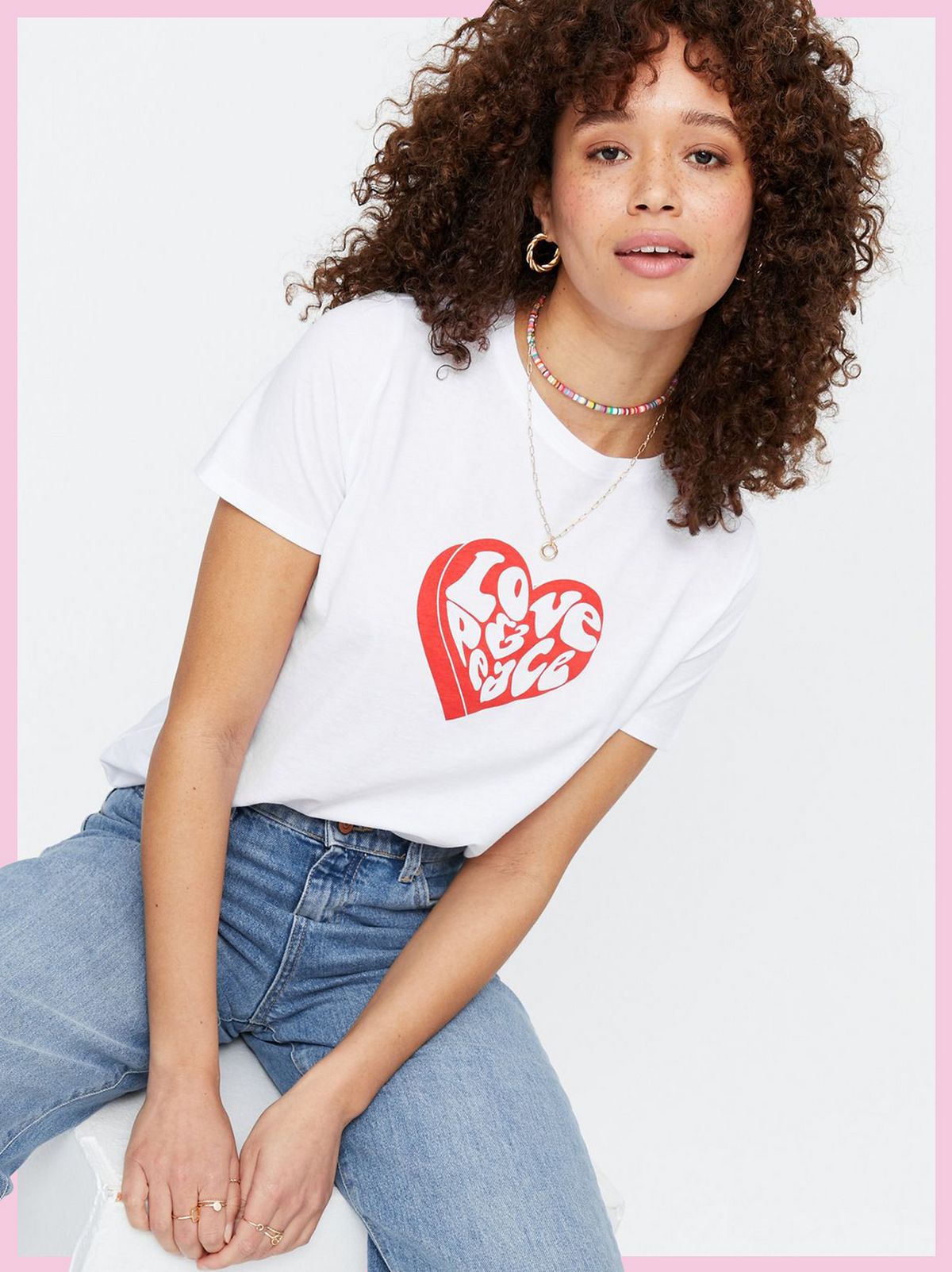 Woman wearing a White Heart Love and Peace Logo T-Shirt and blue jeans
