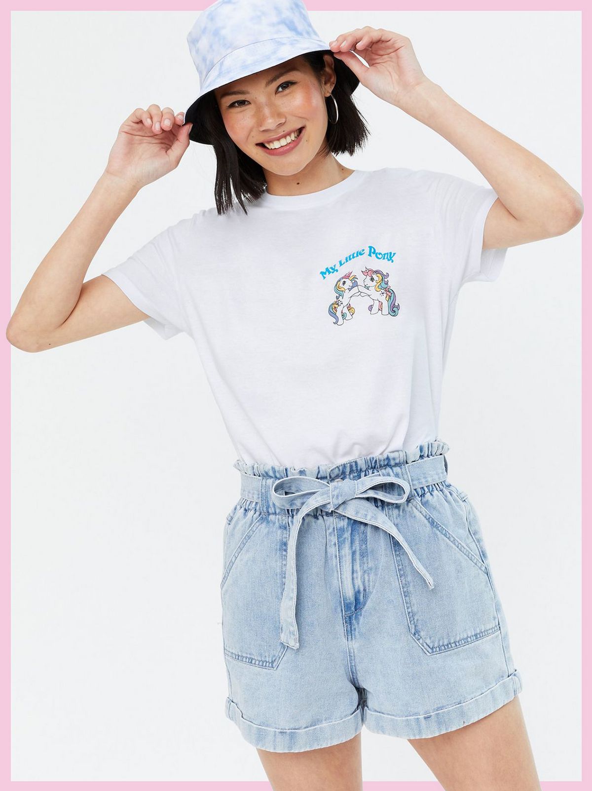Woman wearing a White My Little Pony Logo T-Shirt, blue denim shorts and bucket hat
