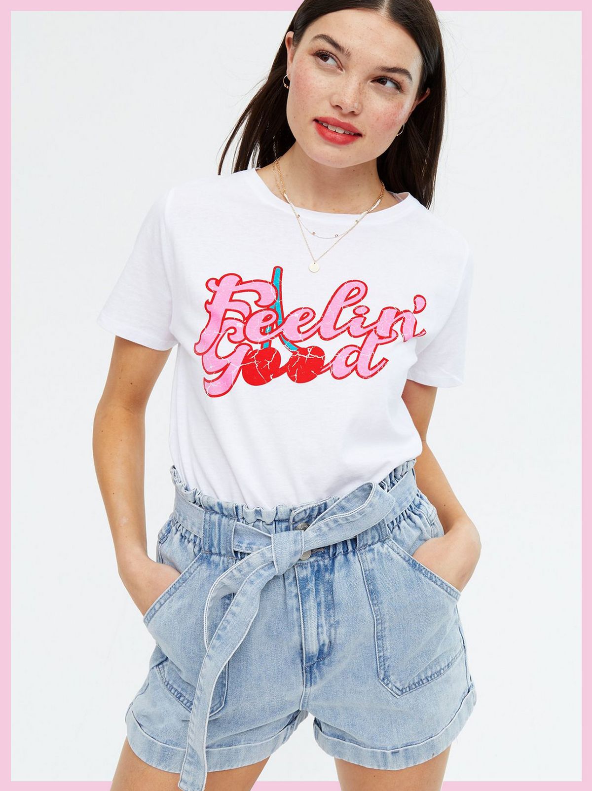 Woman wearing a White Feelin' Good Cherry Logo T-Shirt and blue jean shorts