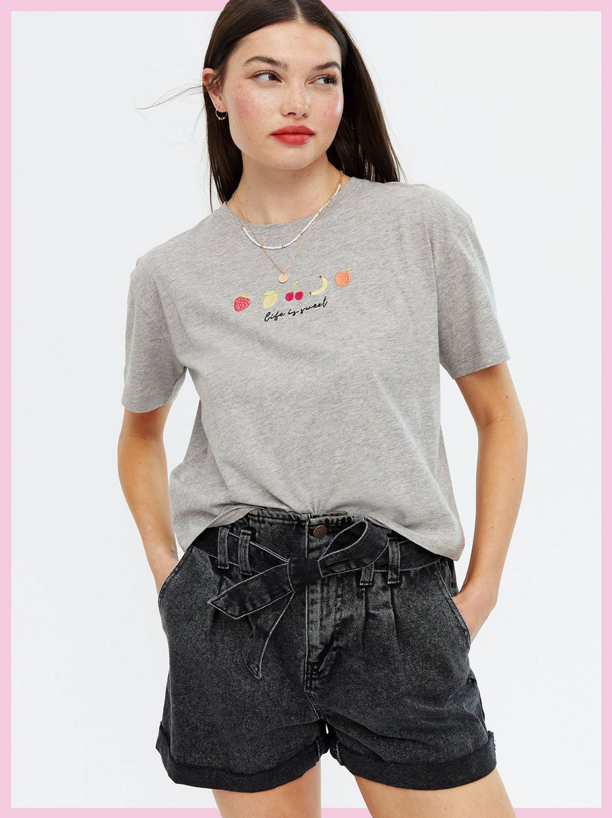 Woman wearing a Pale Grey Life Is Sweet Embroidered Logo T-Shirt and black denim shorts
