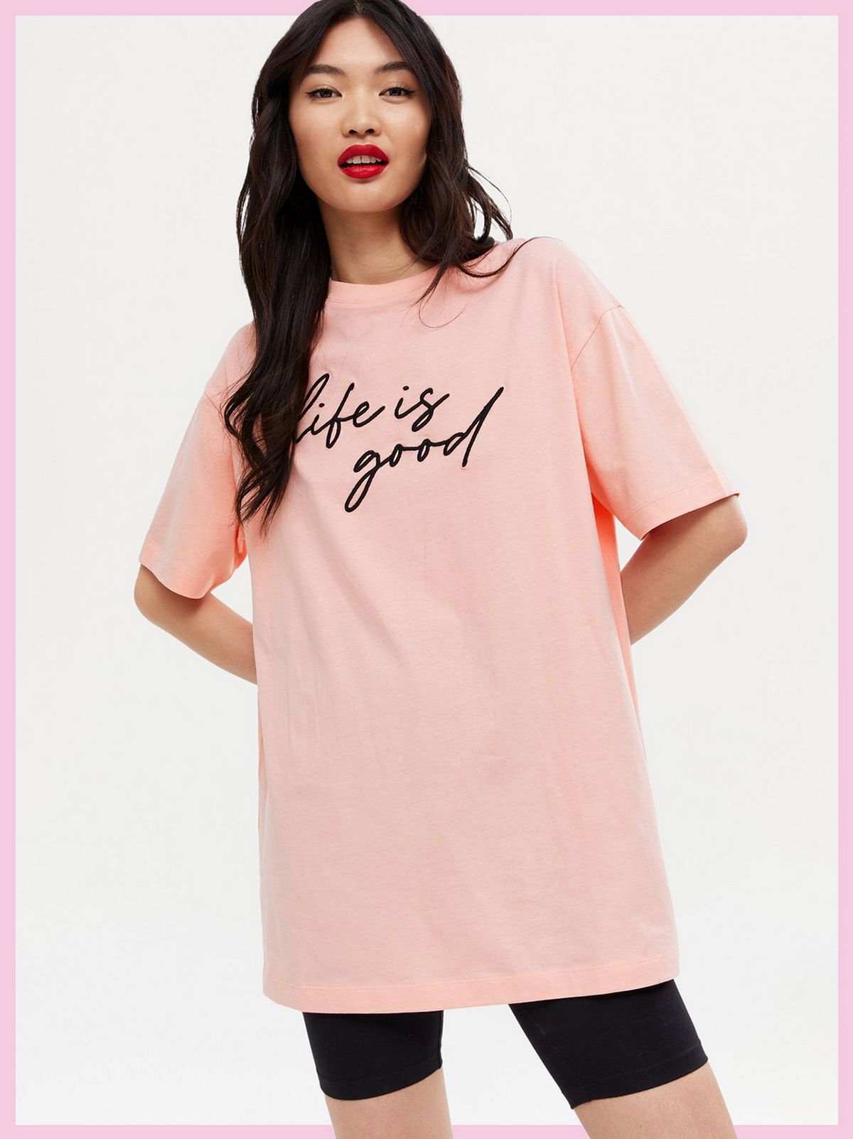 Woman wearing a Coral Life Is Good Oversized Logo T-Shirt and black cycling shorts