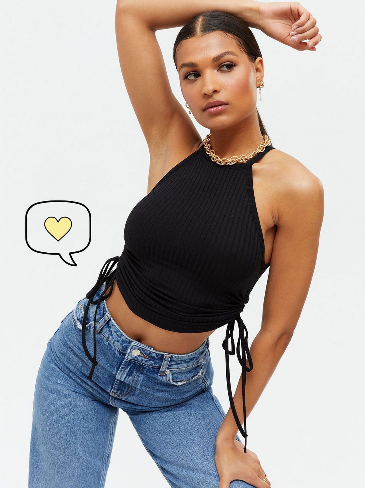 Woman wearing a black ribbed crop top and blue jeans