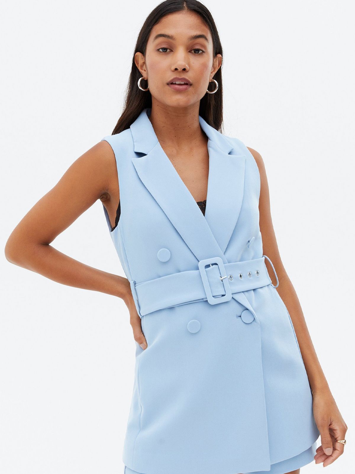 Woman wearing a blue button front sleeveless blazer